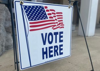 This is a picture of a vote here sign.