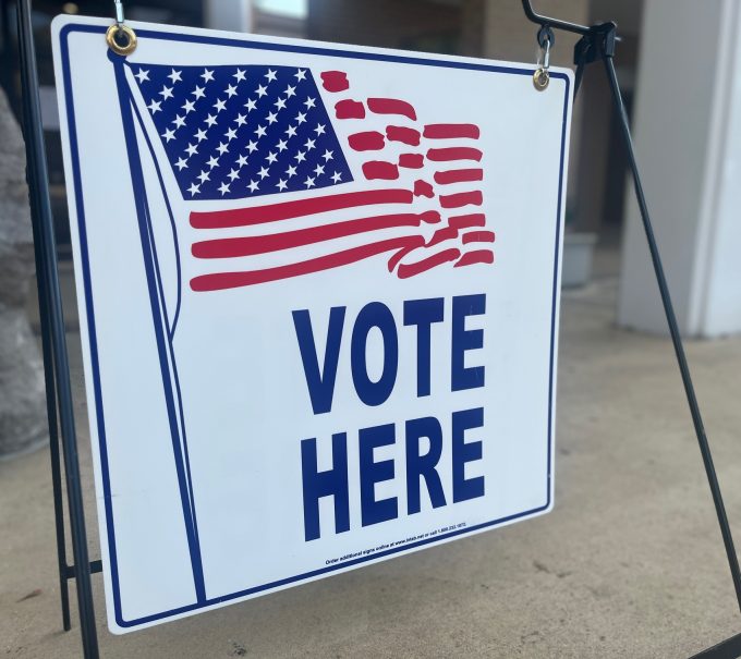 This is a picture of a vote here sign.