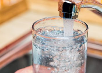 This is a picture of a glass being filled with water from a faucet.