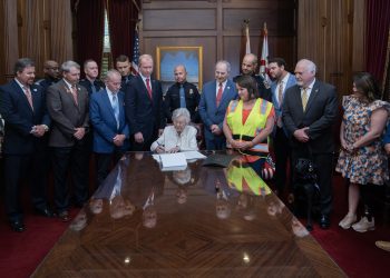 This is a picture of Kay Ivey signing SB341.