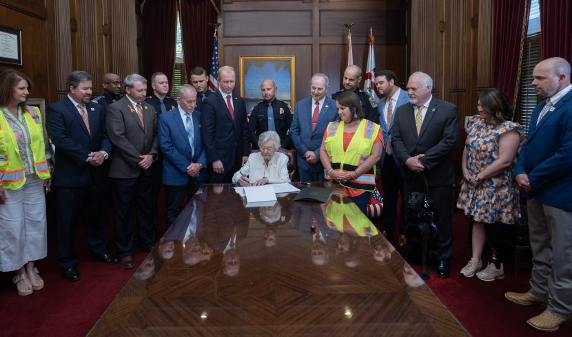 This is a picture of Kay Ivey signing SB341.