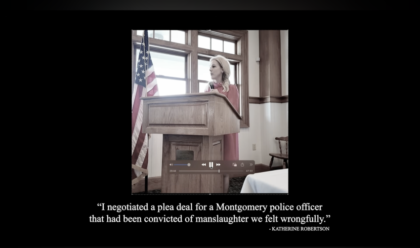 This is a screenshot from the ad of Robertson speaking at a podium.