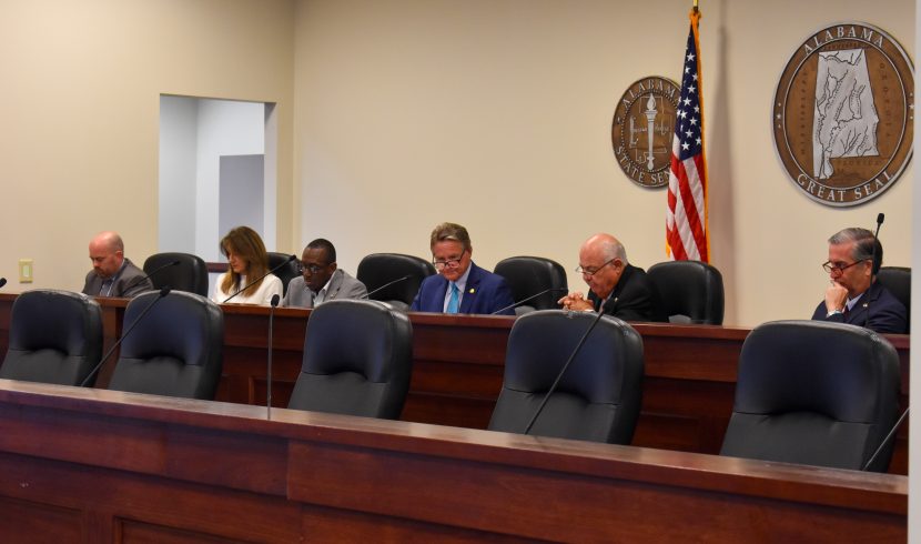 This is a picture of people sitting at a dais in Room 200 in the Alabama State House