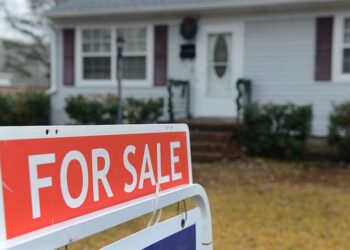 This is a picture of a for sale sign outside of a House.